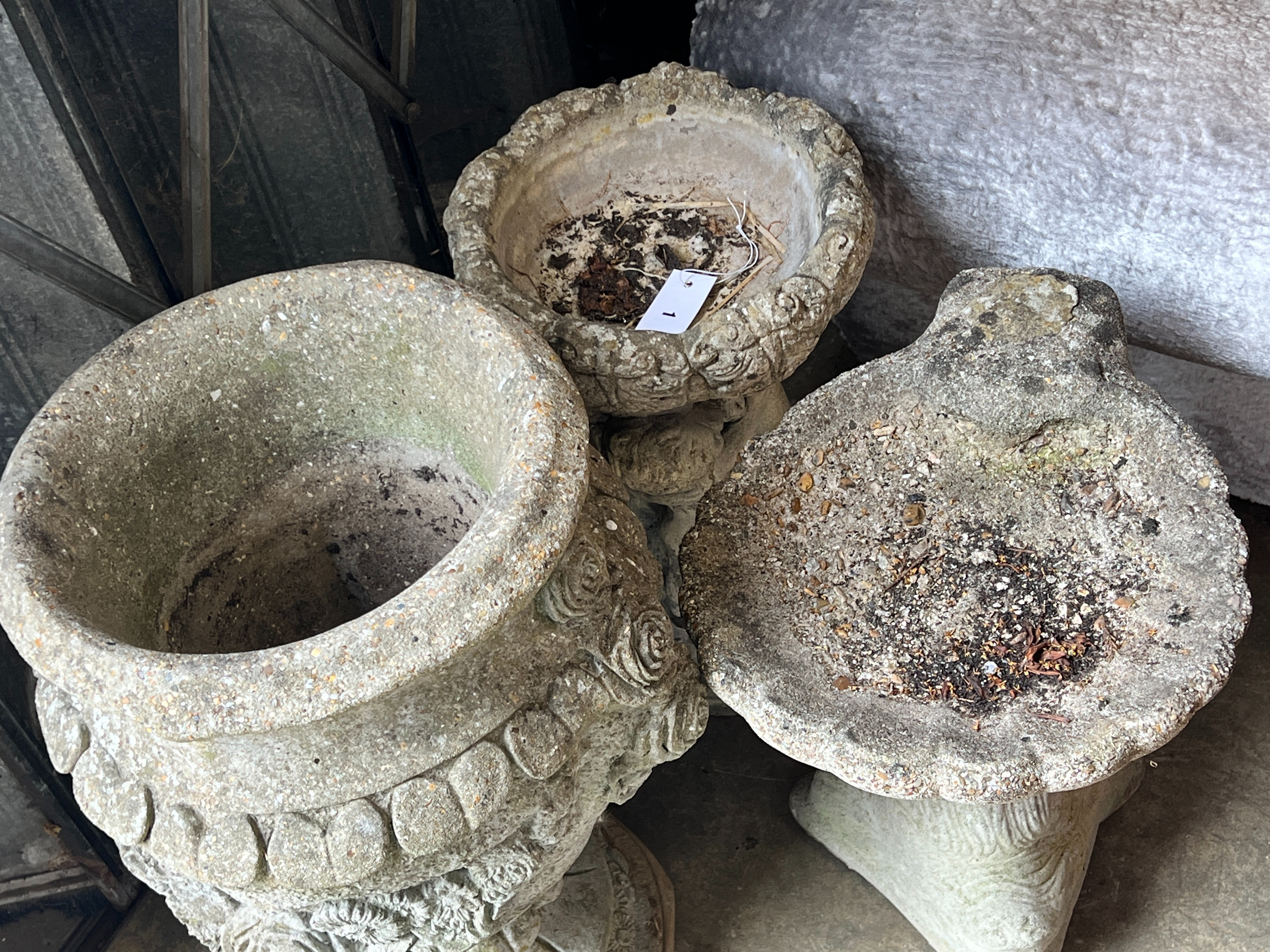 A reconstituted stone garden urn, height 63cm together with two stone bird baths